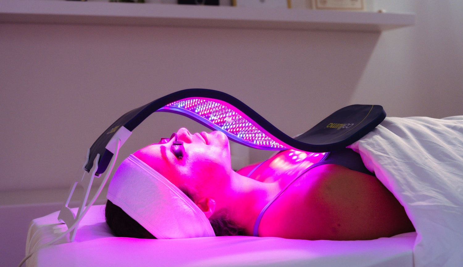 Dispositivo Celluma acceso con dettaglio tre luci LED e ragazza sdraiata con occhialini